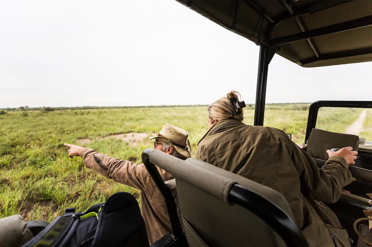 Guide pointing out wildlife across the Serengeti plains